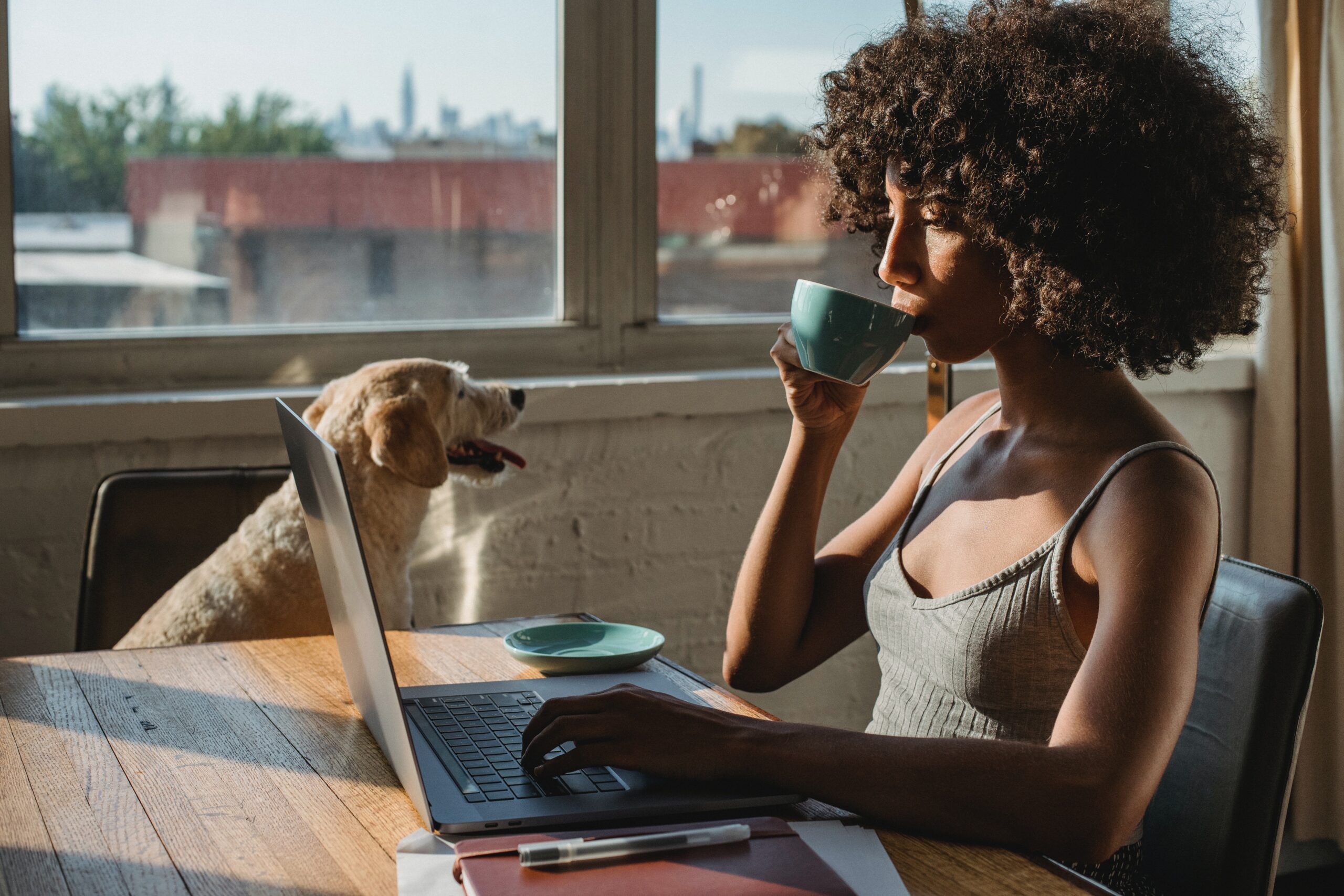 Woman at her laptop with dog working on customer retention strategies