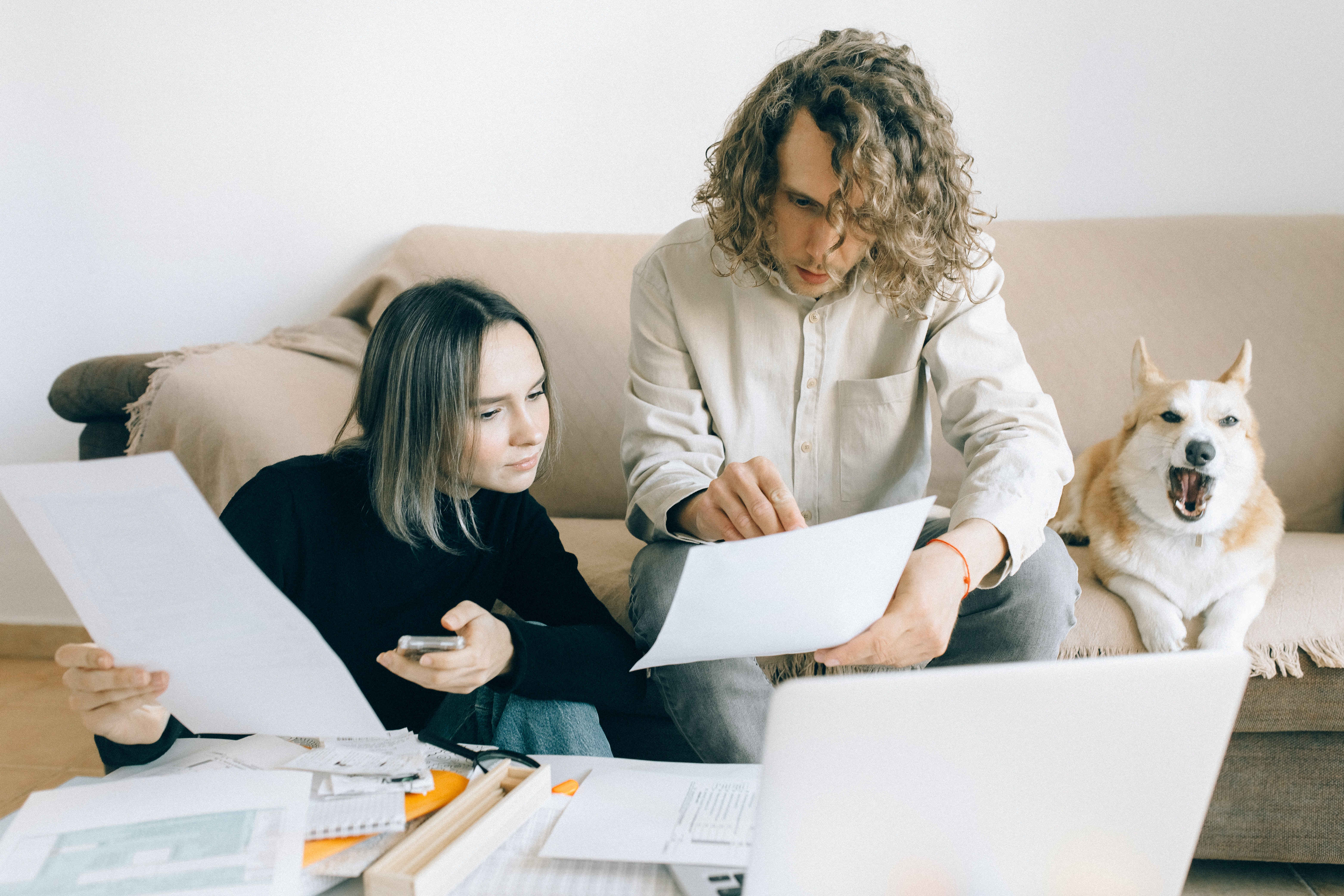Man and Woman Holding Papers at Home Looking Into Pet Business Insurance
