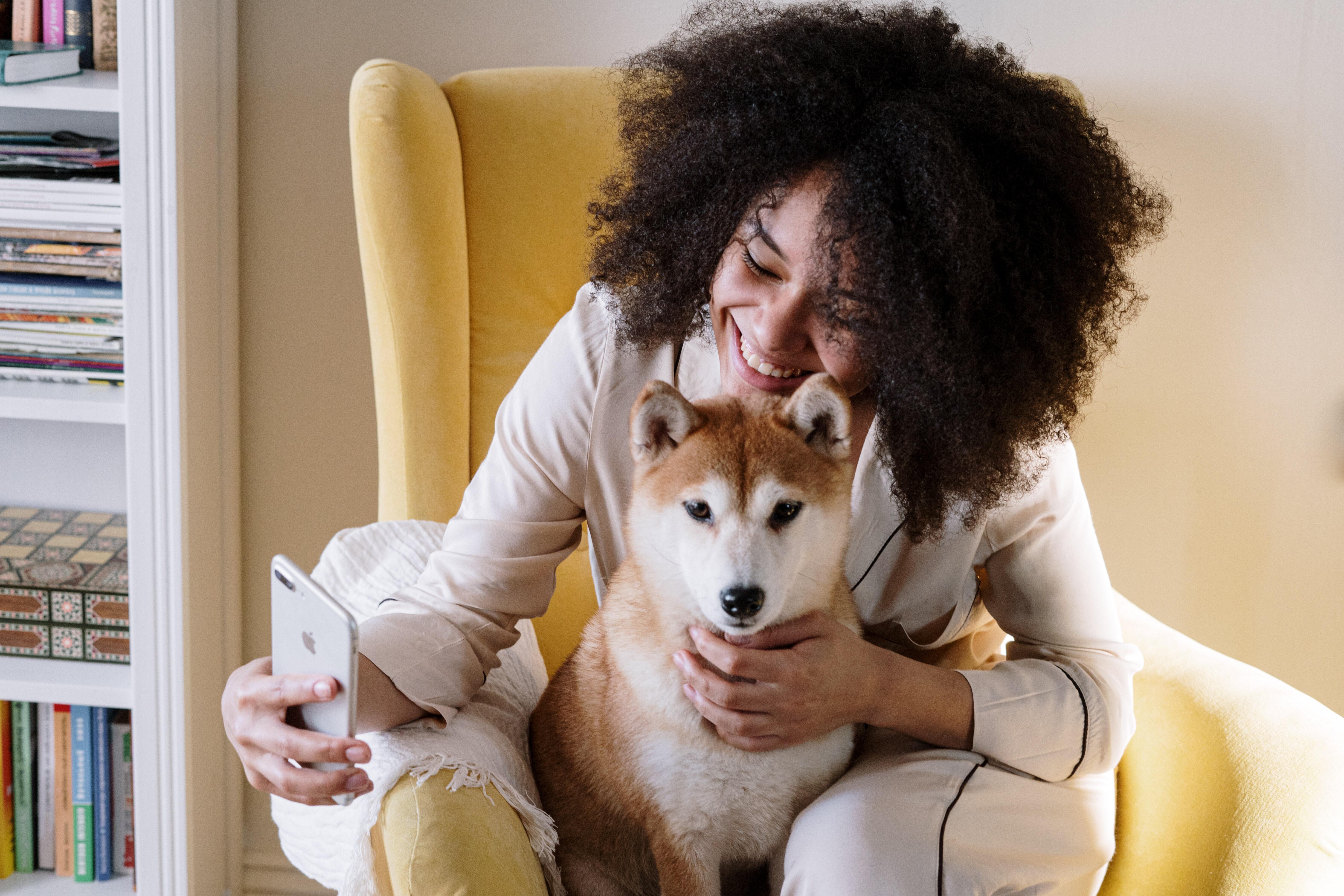 pexels-cottonbro-studio-4056512 A woman taking a selfie with a dog while running her pet sitting business.