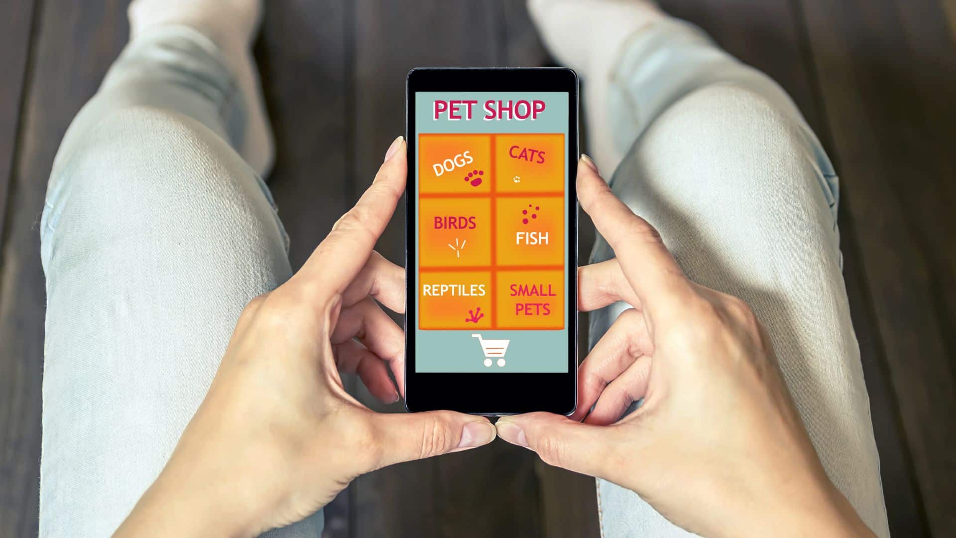 A top down, close up image of someone holding their phone. On the phone screen is a menu for an online pet shop business.